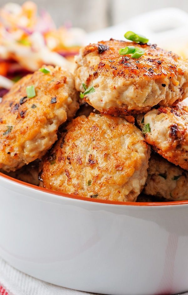 some crab cakes in a white bowl on a table