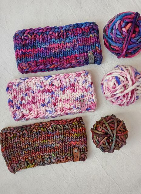 several different colored yarns are laid out on a white surface with balls of yarn