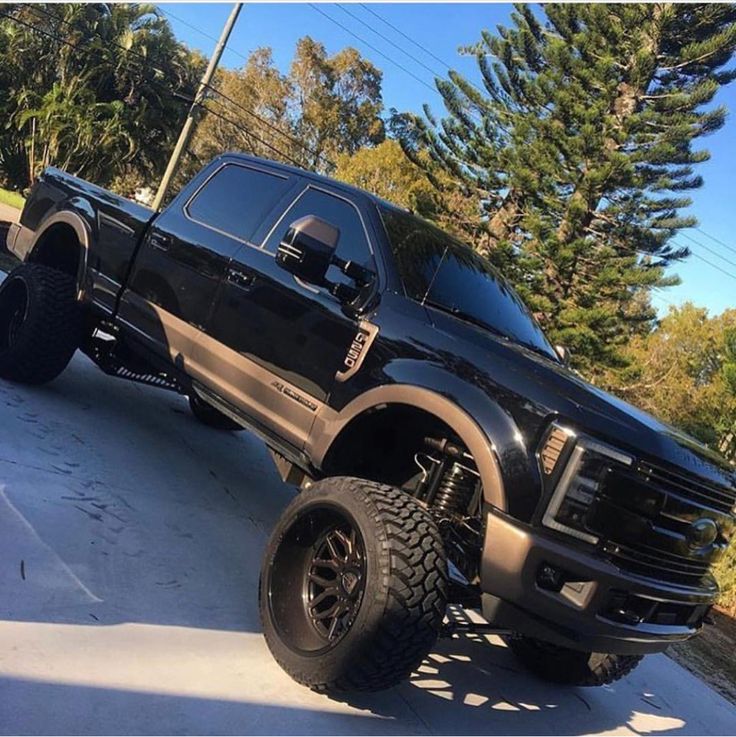 a black truck is parked on the street