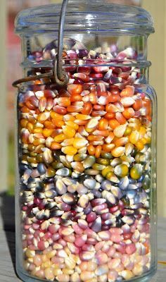 a jar filled with corn sitting on top of a wooden table