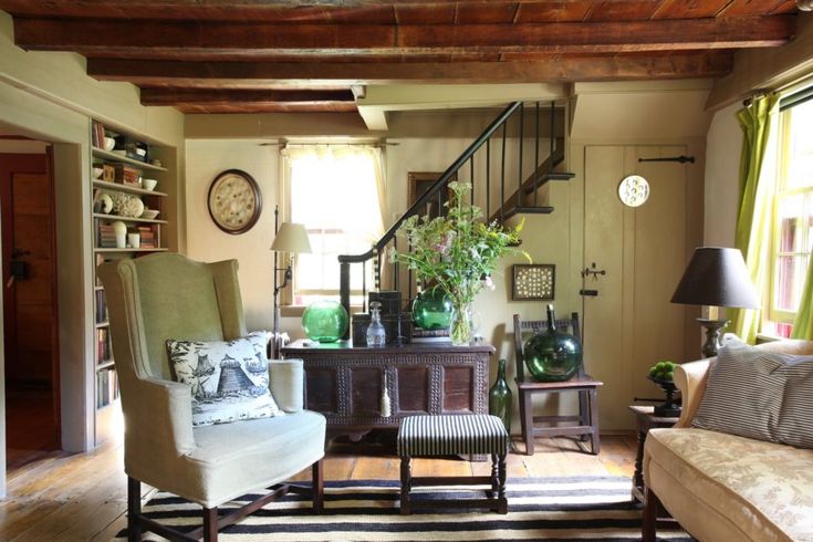 a living room filled with furniture and a stair case in front of a clock on the wall