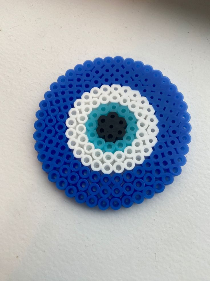 a blue and white beaded object sitting on top of a table