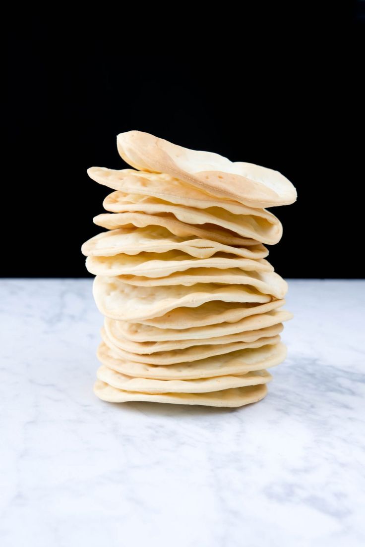 a stack of tortilla chips sitting on top of a white marble countertop