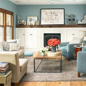 a living room filled with furniture and a fire place under a painting on the wall