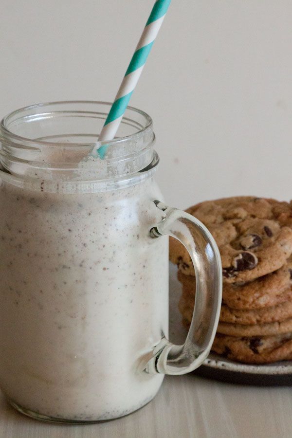 cookies and milk in a mason jar next to a cookie on a plate with a straw