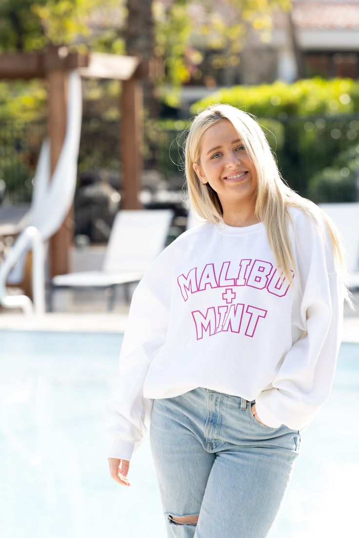 Introducing our Malibu and Mint Sweatshirt, a perfect blend of comfort and coastal vibes for those who embrace the sun, sand, and sea. Crafted with soft, breathable fabric, this sweatshirt is your go-to companion for breezy beach days or cozy evenings by the bonfire. The design captures the essence of pure joy with playful and vibrant hues that reflect the cheerful spirit of beach life. Embrace the sunshine in style and spread positive vibes with this Malibu and Mint Sweatshirt – where comfort meets the carefree allure of the ocean. *For an oversized fit, size up 1-2 sizes* **Washing Instructions: For best results, wash garment inside out in cold water. Avoid hot water to preserve fabric quality. Hang to dry to maintain shape and color vibrancy. Do not tumble dry or bleach. Trendy Cotton Sweatshirt For Vacation, Sporty Long Sleeve Sweatshirt For The Beach, White Casual Sweats With Graphic Print, Casual White Sweats With Graphic Print, Casual White Graphic Print Sweats, Casual White Sweats For Leisure, Casual Cotton Sweatshirt For Vacation, Casual Cotton Sweatshirt For The Beach, Beach Cotton Crew Neck Sweatshirt