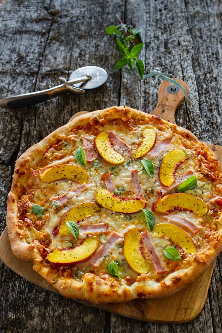 a pizza sitting on top of a wooden cutting board next to a fork and knife