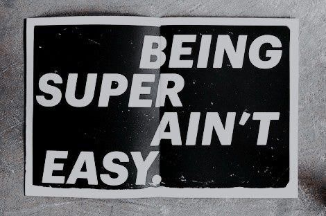 a black and white sticker with the words being super ain't easy on it