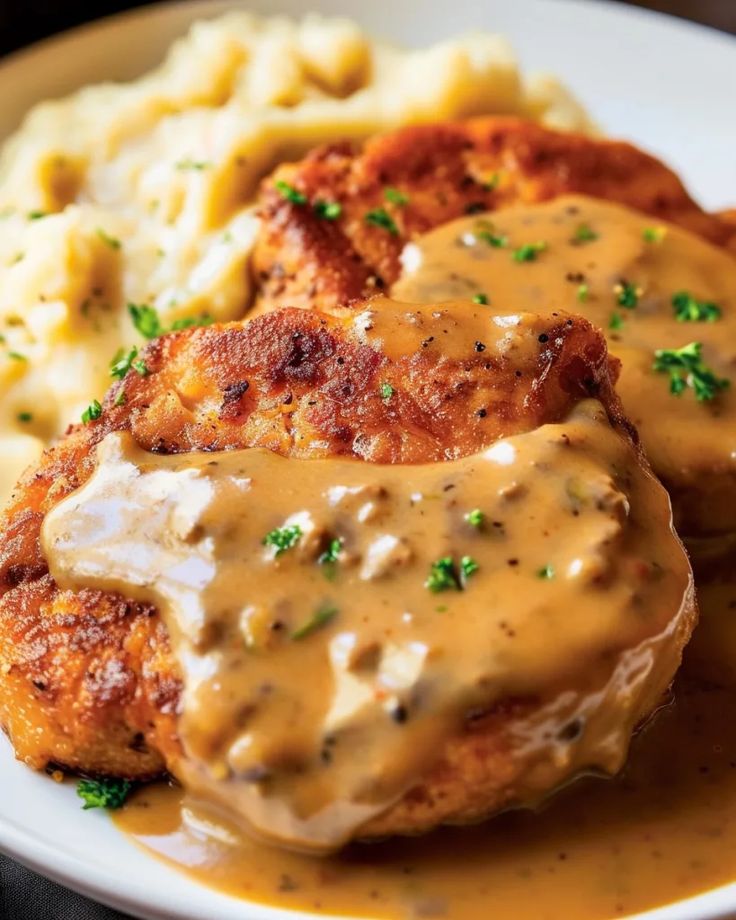 chicken with gravy and mashed potatoes on a plate