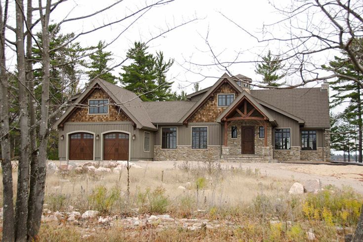 a large house in the woods with lots of windows