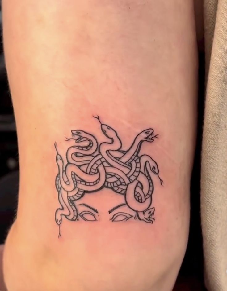 a woman's foot with a tattoo on it that has a snake in the middle