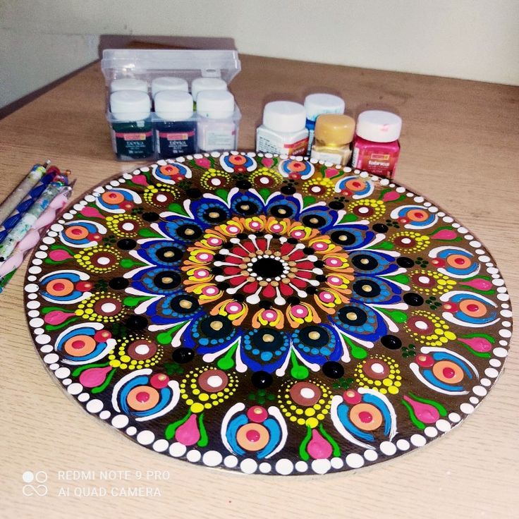 a table topped with lots of crafting supplies on top of a wooden table covered in paint