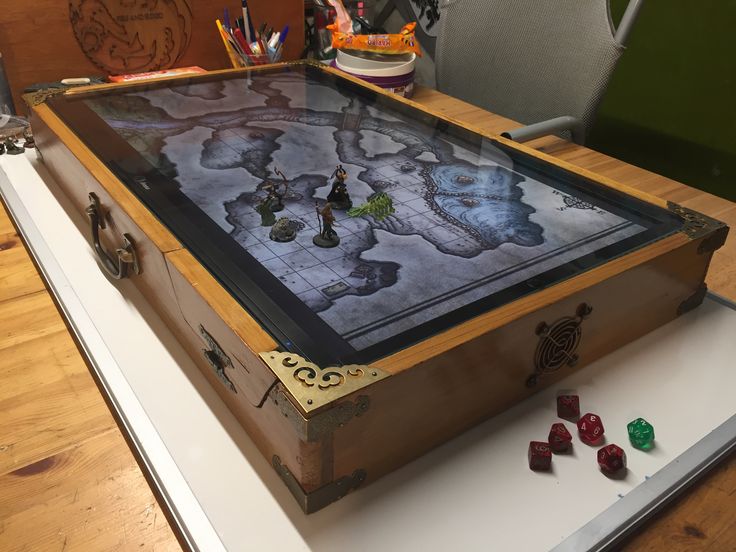 a wooden box sitting on top of a table filled with dices and other items