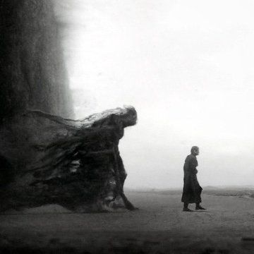 black and white photograph of a man walking past a large tree trunk in the fog