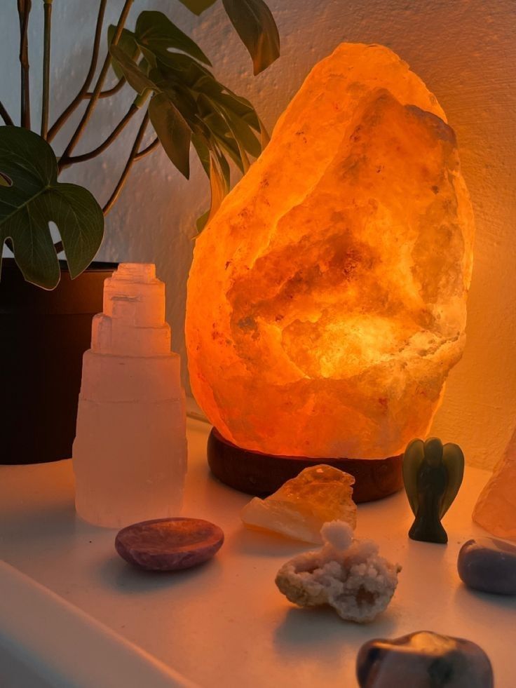 a rock lamp sitting on top of a table next to some rocks and cacti