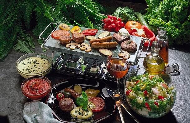 a table topped with lots of different types of food next to vegetables and sauces