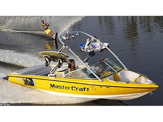 a yellow speed boat with two people riding in the water