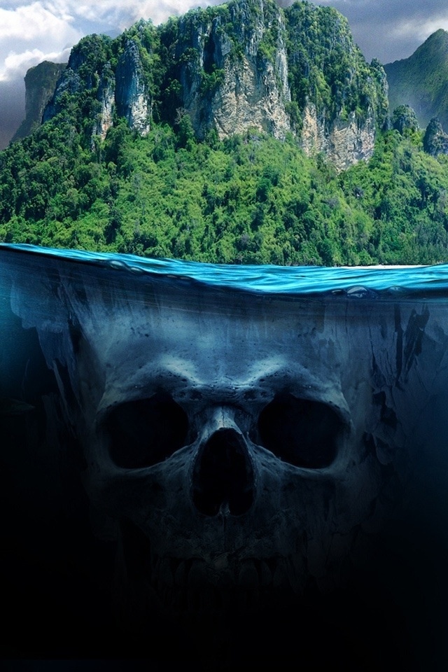 a skull underwater in front of a mountain with trees on the top and water below