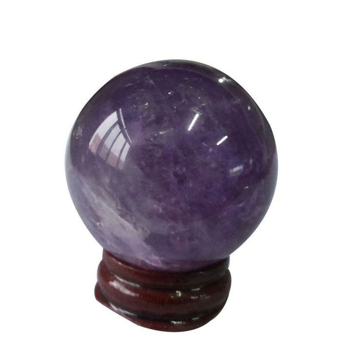 a purple marble ball sitting on top of a wooden stand