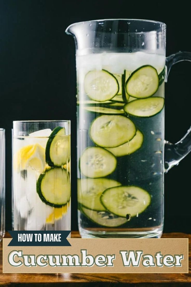 cucumber water in a pitcher with slices of cucumbers and lemon wedges