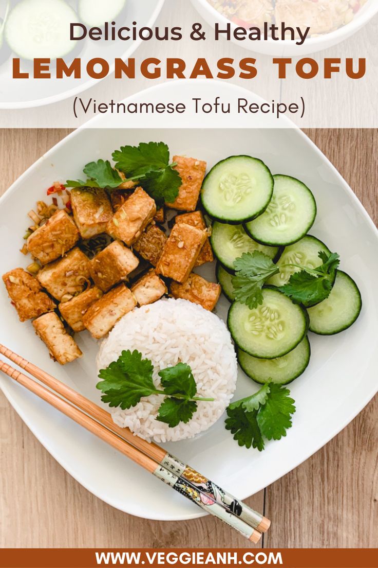 a plate with rice, cucumbers and tofu on it next to chopsticks