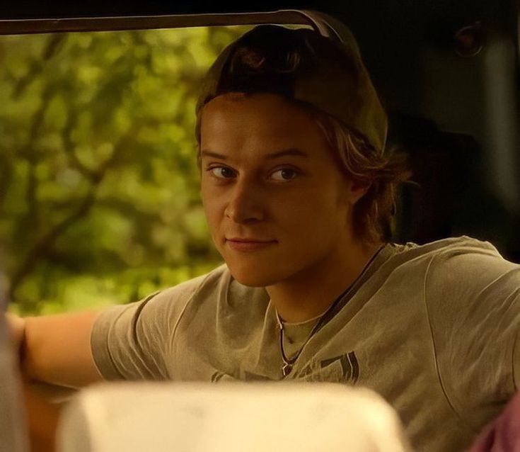 a woman sitting in the passenger seat of a car looking at something off to the side