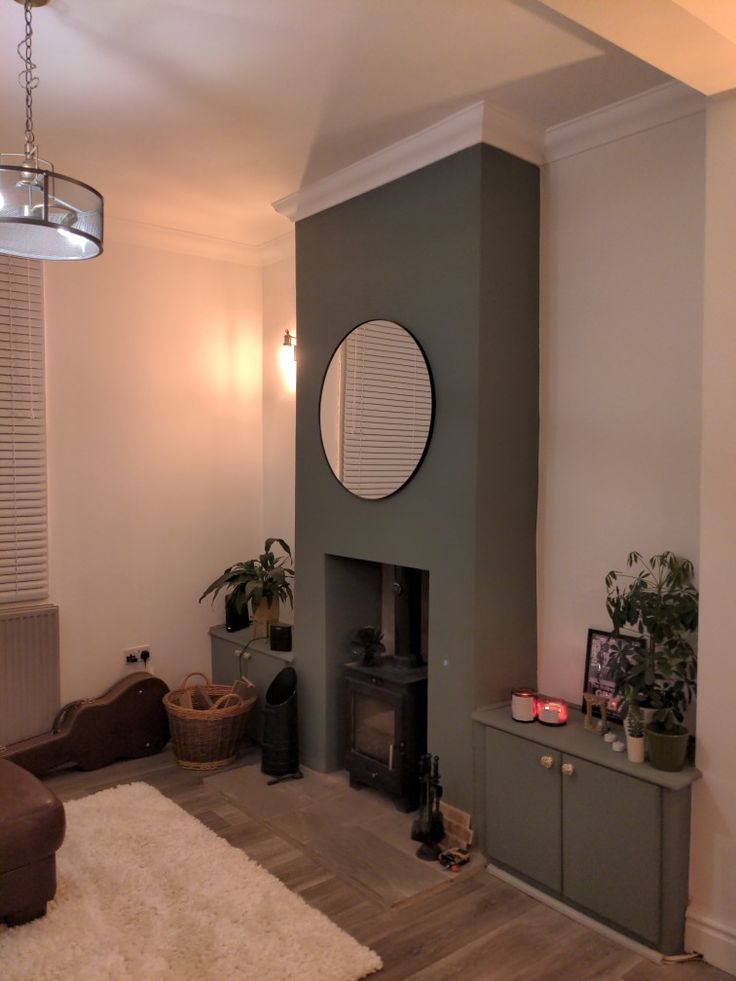 a living room filled with furniture and a fire place next to a wall mounted clock