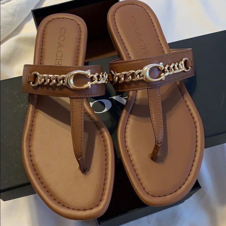 New Never Used Brown Flat Flip Flops, Chic Brown Toe Post Sandals, Coach Brown Open Toe Sandals, Coach Brown Leather Sandals, Chic Coach Flat Heel Sandals, Coach Leather Sandals For Beach, Chic Brown Coach Sandals, Coach Slip-on Sandals With Textured Footbed, Coach Sandals For Vacation With Round Toe