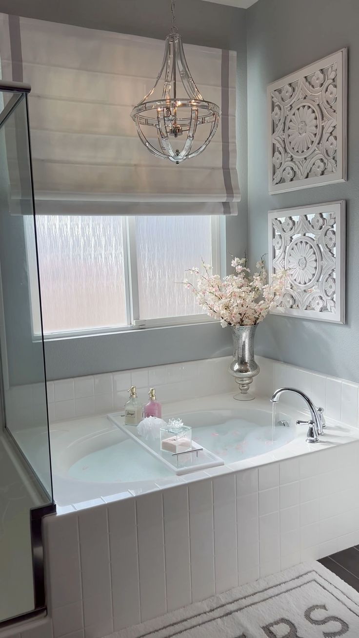 a bathroom with a tub, chandelier and window