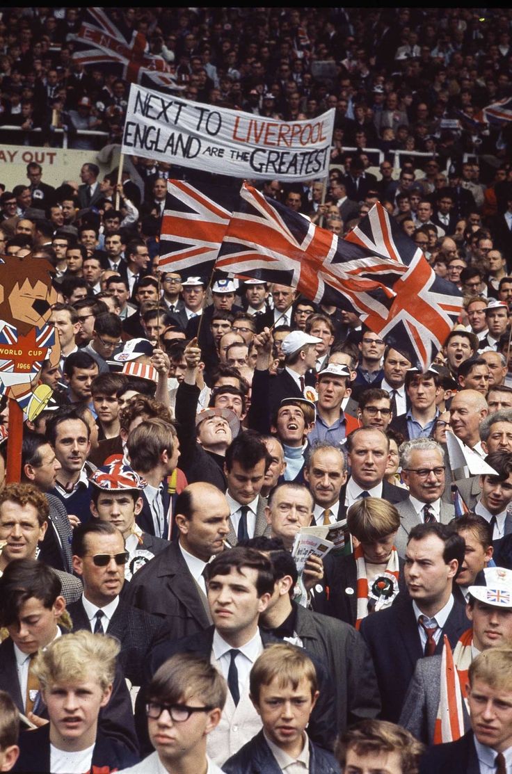 a large group of people in suits and ties at a sporting event with flags on them