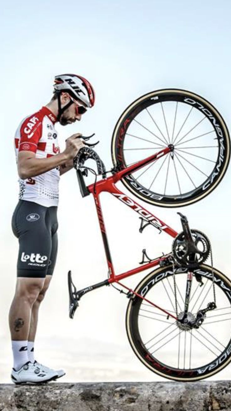 a man standing next to a red bike