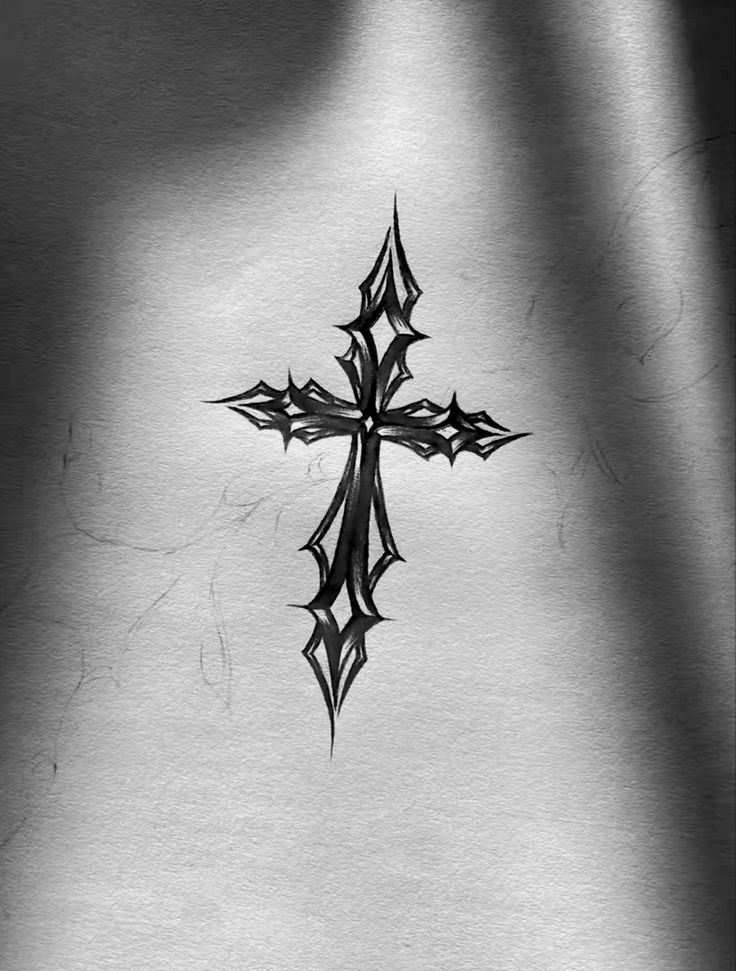 a black and white photo of a cross tattoo