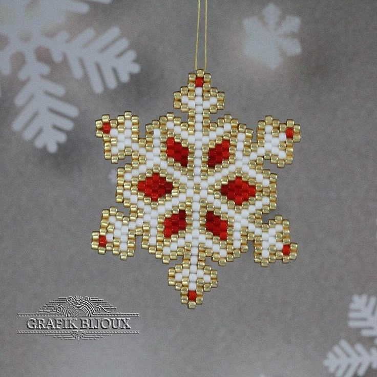 a beaded ornament hanging from a string with snowflakes in the background