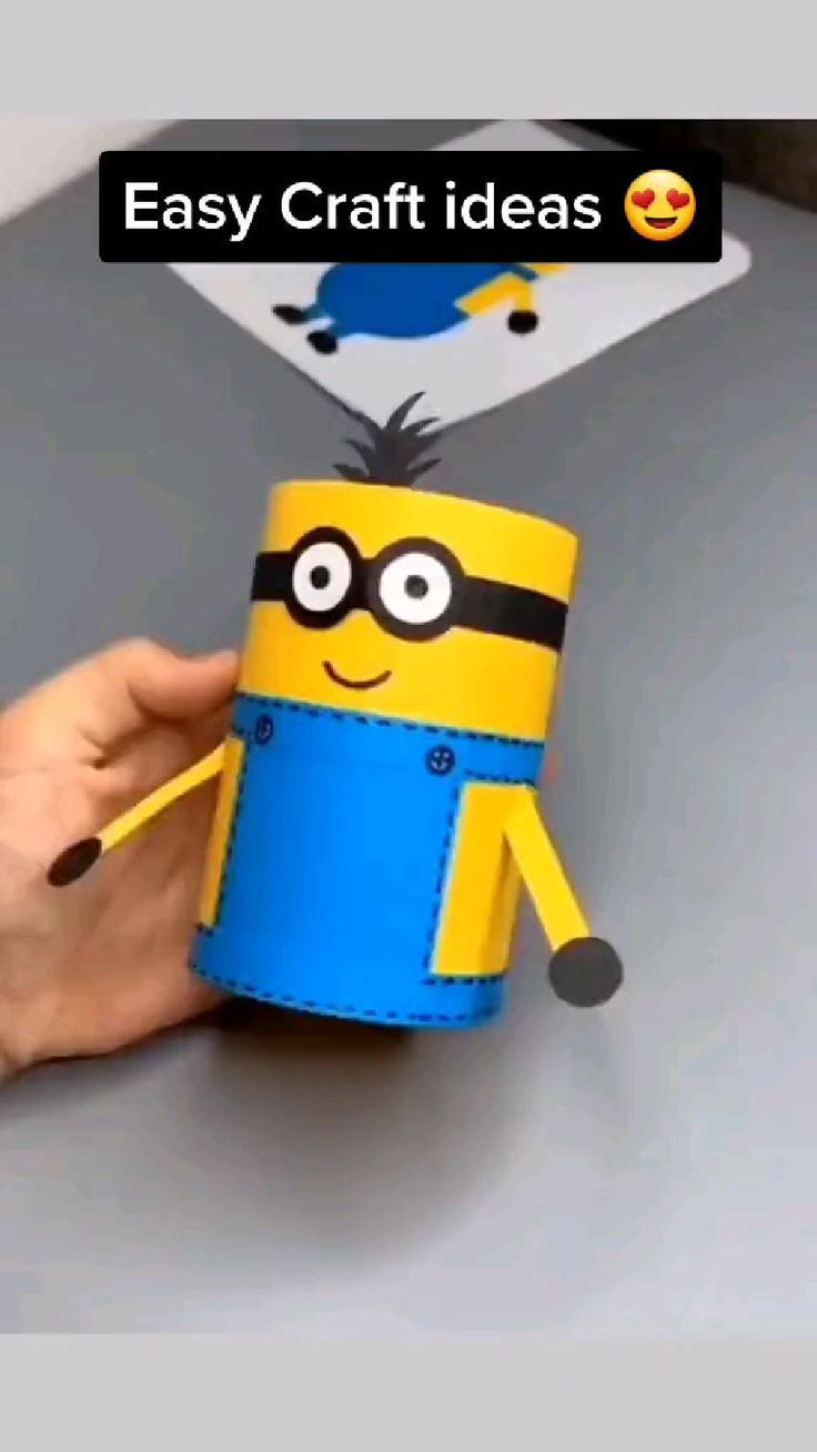 someone is holding up a paper toy with a minion on it