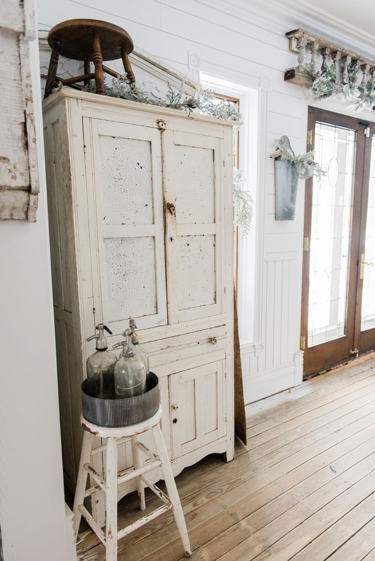 an old white cabinet in the corner of a room