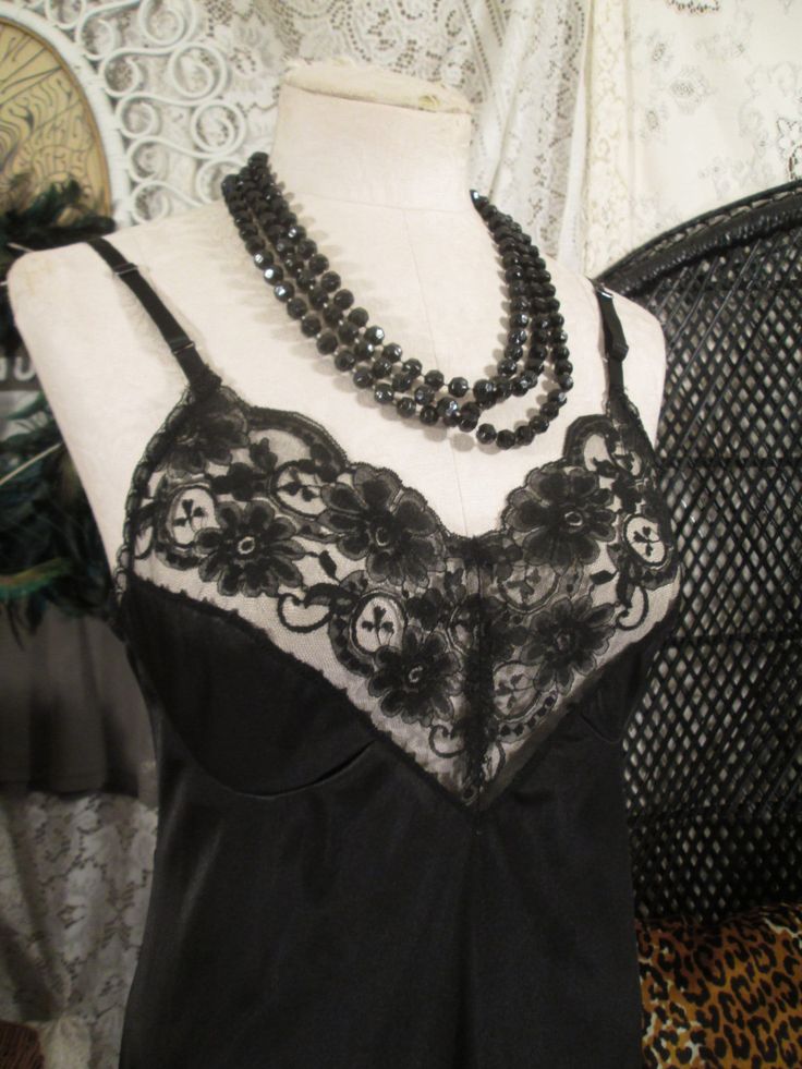 Silky black nylon satin slip with beautiful sheer lace, this vintage black slip is really lovely. The lace pattern has daisy flowers and 3 leaf clovers. Deep v neckline is sheer with princess seam cups, of lace and satin knit.  This shiny black 70s vintage slip is JC Penneys, made of Antron nylon that tries not to cling, ride up and stay silky and smooth under a dress or skirt. A  different style of Vintage Wedding lingerie.  The slip is soft all silky knit nylon. Skinny adjustable matching black 1/4" wide straps measures a 34, medium size, with a bit of stretch.  bust - 36"  waist - 31" hips - 38" full Length - 38" - 40" (adjustable) excellent condition. Machine wash and dry, gentle. the front door of the shop: www.etsy.com/shop/funkomavintage the website  -- funkomavintage.com handmade s Black Satin Camisole With Lace Trim, Black Sleeveless Camisole With Lace Patchwork, Evening Lace V-neck Camisole, Black Delicate Lace Camisole For Summer, Summer Black Lace Camisole, Elegant Black Lace Camisole, Black Delicate Lace Camisole For Night Out, Black Lace Camisole With Delicate Lace, Black Lace Camisole With Delicate Detail