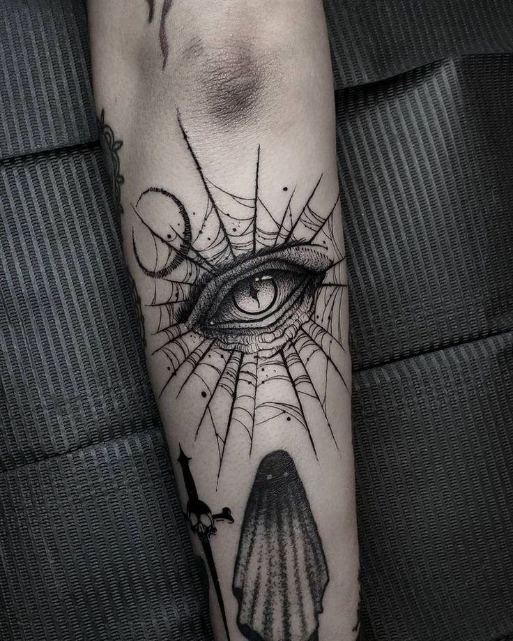 an all seeing eye tattoo on the arm with a black and white image behind it