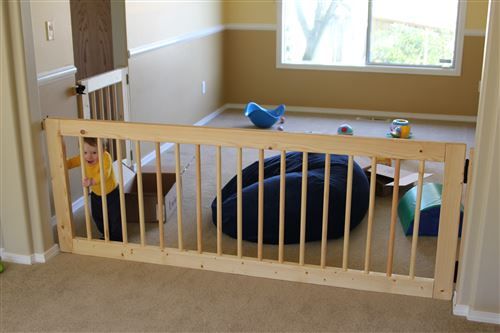 a baby in a crib with toys on the floor