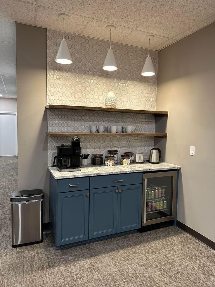 an empty kitchen with blue cabinets and silver appliances