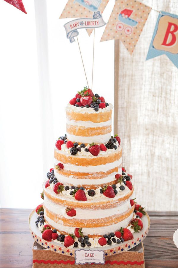 a three tiered cake with strawberries and berries on top