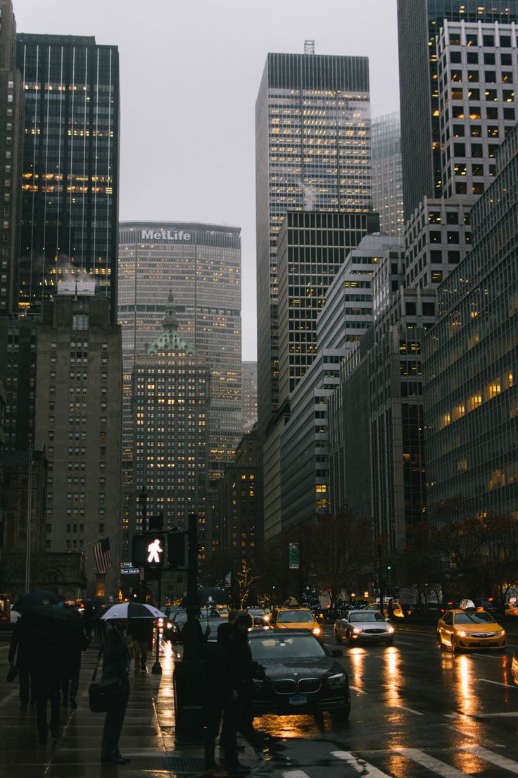 people are walking down the street with umbrellas on a rainy day in new york city