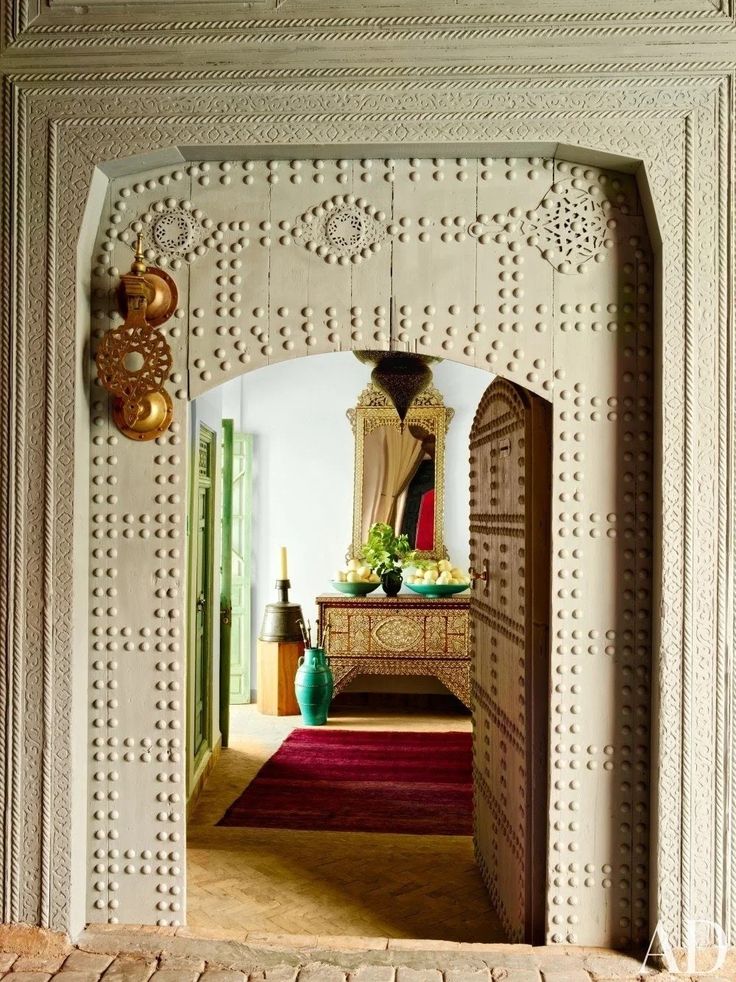 an archway leading to a bedroom with a dresser and mirror on it's wall