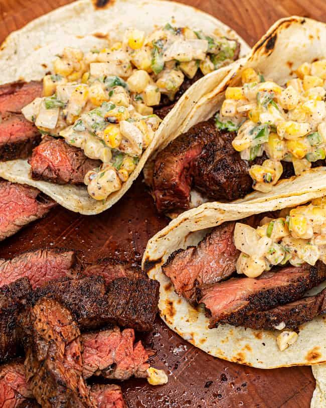 three steak tacos with corn on the side