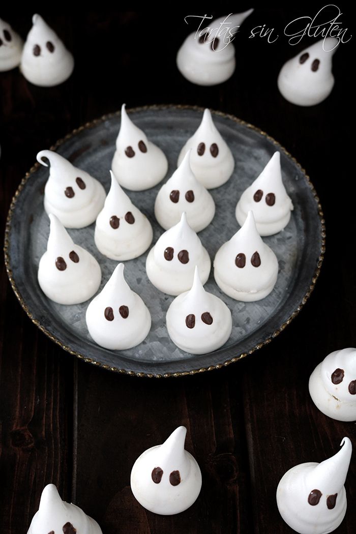 there are many small white chocolates on the plate and one is shaped like ghost