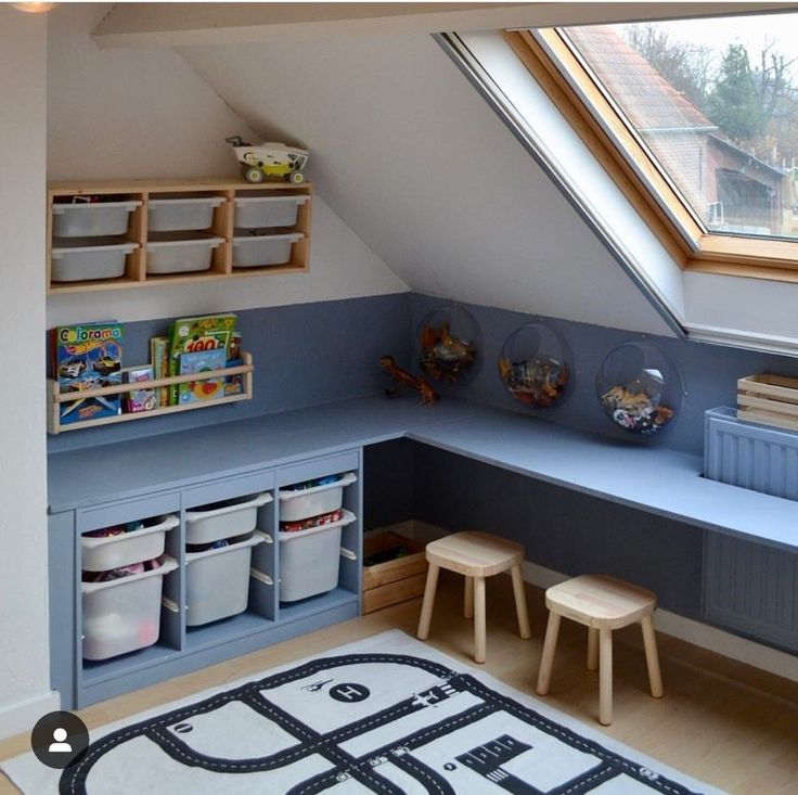 a child's playroom with toys and storage space in the corner, under a slanted roof