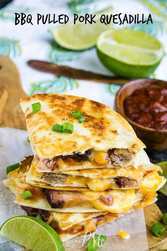 three quesadillas stacked on top of each other with limes and salsa in the background