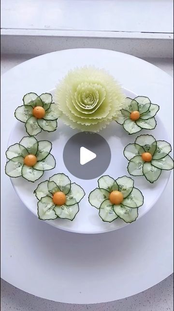 a white plate topped with flowers on top of a table next to an orange flower