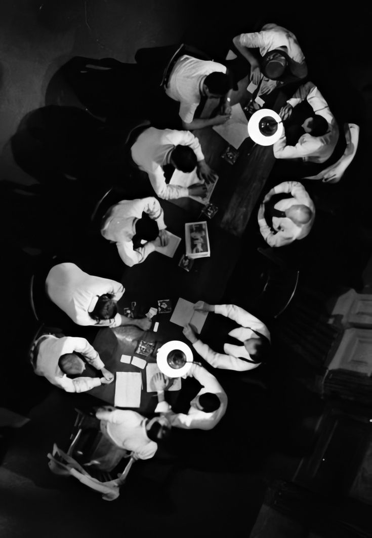 a group of people sitting around a table with doughnuts on top of it