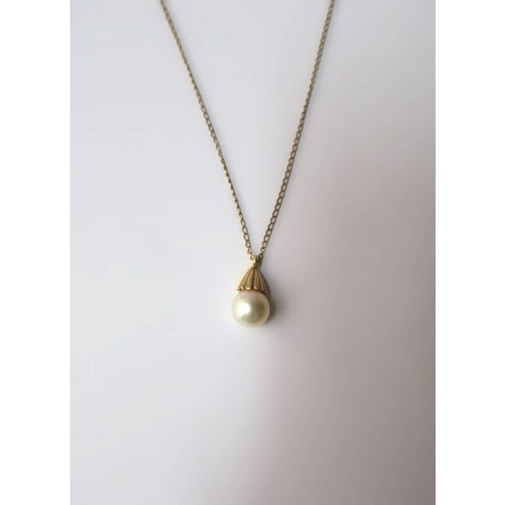 This is part of Chairish’s Fine Jewelry assortment.  A very beautiful white cultured pearl and 14-karat yellow gold necklace, circa mid-20th century. Pearl is very beautiful with a high luster. Pearl has a 14-karat yellow gold crown-like design attached to 14-karat yellow gold necklace. A beautiful piece to wear alone or stack with other necklaces. Very good condition as shown in images. No issues. Dimensions: pearl pendant is over 1/2" long x .25" Width. Necklace, from end to end, measures 19.2 Classic Gold Single Strand Pearl Necklace, Classic Gold Pearl Necklace, Classic Formal Pearl Necklace With Pearl Charm, Classic Gold Jewelry With Pearl Charm, Gold Jewelry With Pearl Charm For Formal Occasions, Classic Yellow Gold Pearl Drop Necklace, Classic Formal Pearl Necklace With Pearl Drop, Gold Akoya Pearl Necklace In Timeless Style, Refined Yellow Gold Pearl Necklace