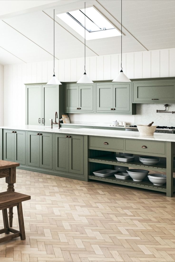 an empty kitchen with green cabinets and wooden table in front of the stove top oven